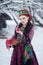 Russian folk style redhead girl holding an apple in a fur coat in winter.