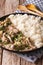 Russian food: beef stroganoff with rice close-up on a plate. Vertical