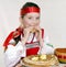 Russian girl eats pancakes with red caviar.