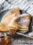 Russian homemade yeast pancakes on blue plate, sprinkled with powdered sugar, wood honey spoon on wooden table. Traditional wheat