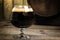 Russian Imperial Stout in snifter glass on wood background and b