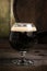 Russian Imperial Stout in snifter glass on wood background and b