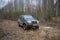 The russian off-road car `UAZ Patriot` in the spring woods