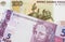 A Russian one hundred ruble note paired with a pink and purple five real bank note from Brazil.