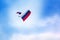 Russian paratrooper jumps with a parachute painted in the colors of the flag of Russia with the Russian flag on clear blue sky