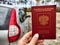 Russian passport in hand of woman. Russian cars banned for entering in Europe. Russian tourism closed during war of