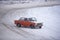 Russian red old car `VAZ Zhiguli` goes fast sideways in winter turning the wheel on the turn of the snow