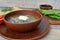 Russian rustic cuisine: green vegetables soup with quail egg, sour cream