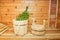 Russian sauna. Two wooden buckets and a birch broom in one of them. Wood background