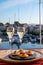 Russian style party with two glasses of white cold champagne, bliny with red caviar and view on Port Grimaud near Saint-Tropez in