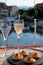 Russian style party with two glasses of white cold champagne, bliny with red caviar and view on Port Grimaud near Saint-Tropez in