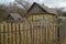 Russian style village. Wooden farmhouse behind a wooden picket fence. Abandonned concept, country and farm in Belarus