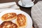 Russian syrniki or sirniki, homemade cottage cheese fritters or pancakes. breakfast with curd pankakes and a cup of coffee