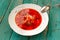 Russian vegetarian borsch with cabbage in white plate on turquoi