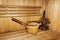 Russian wooden sauna room, lumber rustic bench in bath house, wooden bucket with water and birch leaf broom, healthy leisure