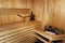 Russian wooden sauna room, lumber rustic bench in bath house, wooden bucket with water and birch leaf broom, healthy leisure