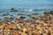 Rust-colored boulders form stretch of beach in Newcastle, Australia