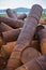 Rusted barrels on the shore.