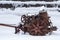 Rusted farm equipment in snow