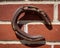 Rusted horse shoe on red brick wall