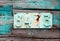 Rusted house number on grunge green wall