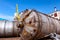 Rusted huge metal silos are placed on the ground for cutting to scrap steel