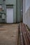 Rusted metal pipes in a downtown alley leading to a green entry