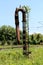 Rusted metal railway white and black water pump with rusted and overgrown metal ladder mounted on side