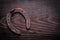 Rusted obsolete horsehoe on vintage dark wood board copy space i