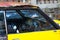 Rusted old broken black and yellow car parked in an urban road, Cape Town