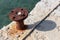 Rusted old iron mooring bollards mounted on concrete pier