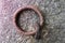 Rusted Q Shaped Iron Ring on Stone