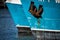 Rusted rugged Anchor on blue fishing ship