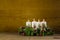 Rustic advent wreath or crown with four burning white candles.