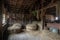 rustic barn with freshly baled hay for the horses, and saddle hanging on wall