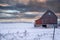 Rustic barn in Minnesota on a winter sunset day, with hoar frost