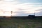 A Rustic Barn and Wildmill at Sunset