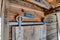 Rustic bathroom exterior with sliding wooden door and rusty corrugated roof