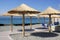 Rustic beach umbrellas and chairs on shore of lake