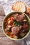 Rustic Beef Bourguignon in a bowl on a table close-up. vertical