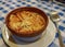 Rustic bowl of Castilian soup.  Onion soup on a table with blue checkered tablecloth.