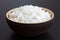 Rustic bowl of cooked white rice on dark surface