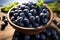 A rustic bowl holds a harvest of juicy blueberries, beautifully adorned