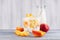 Rustic breakfast with corn flakes, slice peach and milk bottle on white wood board.