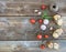 Rustic breakfast set. Sandwiches with smoked meat, cherry-tomatoes, cucumbers, garlic, thyme and basil on rough wood background