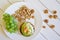 Rustic breakfast on white boards: a bunch of grapes, cake, pistachios, walnuts