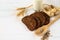 Rustic breakfast on a white wooden background - bread, sunflower, seeds on a light spoon, ears of wheat and a glass of milk