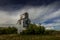 Rustic buildings and grain elevator stand in what used to be the town of Sharples Alberta Canada