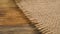 Rustic burlap fabric textile on a wooden surface. Rural rough background