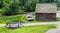 Rustic cabin with weathered boat and wooden foot bridge